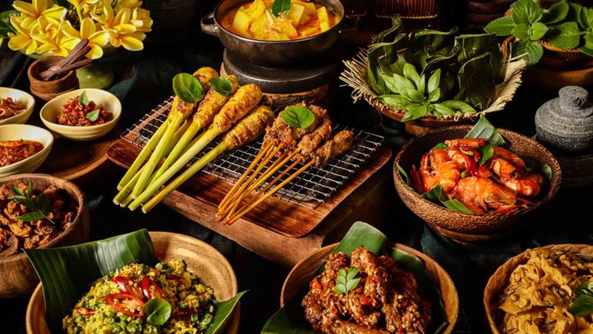 Kuliner Bali: Ekspresi Budaya dalam Ragam Rasa Kuliner Bali tidak hanya sekadar tentang rasa, tetapi juga merupakan ekspresi dari kekayaan budaya dan tradisi yang mendalam. Dibalik setiap hidangan, terdapat kisah panjang tentang sejarah, kepercayaan, dan kearifan lokal yang diwariskan dari generasi ke generasi. Dalam artikel ini, kita akan menjelajahi berbagai hidangan khas Bali, yang membawa kita pada perjalanan gastronomi yang memikat dan memperkaya jiwa. Nasi Campur: Paduan Harmonis Aroma dan Rasa Memulai perjalanan kuliner kita, Nasi Campur Bali menjadi kegemaran lokal dan wisatawan. Hidangan ini terdiri dari nasi yang disajikan dengan berbagai lauk pauk seperti ayam betutu, sate lilit, lawar, dan telur dadar, memberikan pengalaman kuliner yang lengkap dalam satu piring. Paduan harmonis antara aroma rempah-rempah dan rasa lezat menjadikan Nasi Campur sebagai simbol dari keberagaman kuliner Bali. Babi Guling: Kelezatan Tradisional yang Tak Tertandingi Selanjutnya, Babi Guling merupakan hidangan khas Bali yang paling terkenal. Babi utuh dipanggang dengan rempah-rempah khas Bali hingga kulitnya renyah dan dagingnya empuk. Proses memasak yang panjang dan detail memberikan cita rasa yang kaya dan lezat. Babi Guling menjadi simbol dari tradisi penyajian daging dalam upacara keagamaan dan perayaan di Bali. Lawar: Perpaduan Unik dari Sayuran dan Daging Bergerak lebih jauh, Lawar adalah hidangan tradisional Bali yang terbuat dari campuran daging cincang dan sayuran, seperti kelapa, kacang panjang, dan kacang kedelai. Bumbu rempah yang khas memberikan rasa yang khas dan menggugah selera. Lawar tidak hanya menyajikan rasa yang lezat tetapi juga mencerminkan filosofi hidup berkelanjutan dan keberagaman masyarakat Bali. Sate Lilit: Sentuhan Manis dan Pedas dalam Setiap Gigitan Selanjutnya, Sate Lilit adalah hidangan sate yang terbuat dari daging cincang yang dibungkus menggunakan batang serai. Daging yang dicampur dengan rempah-rempah khas Bali memberikan cita rasa yang unik, dengan sentuhan manis dan pedas yang meresap dalam setiap gigitan. Sate Lilit bukan hanya hidangan yang lezat tetapi juga merupakan simbol dari kreativitas dan keahlian dalam memasak. Laklak: Manisnya Pencucian Hati dengan Camilan Tradisional Mengakhiri perjalanan kuliner kita, Laklak adalah camilan tradisional Bali yang terbuat dari tepung beras yang dicampur dengan kelapa parut dan gula merah, kemudian dipanggang hingga matang. Hidangan manis ini sering disajikan dengan taburan kelapa parut dan gula merah, memberikan cita rasa yang lezat dan menyegarkan. Laklak tidak hanya memanjakan lidah tetapi juga menyiratkan kehangatan dan kebersamaan dalam setiap gigitannya. Kesimpulan Kuliner Bali bukan hanya tentang makanan, tetapi juga merupakan cerminan dari kekayaan budaya dan tradisi yang melekat dalam setiap hidangannya. Dibalik setiap hidangan, terdapat cerita panjang tentang sejarah, kepercayaan, dan kearifan lokal yang membentuk identitas kuliner Bali. Dengan ragam rasa dan aroma yang memikat, kuliner Bali tidak hanya memuaskan perut tetapi juga memperkaya jiwa, memperkuat kebanggaan akan warisan budaya yang kaya dan unik.